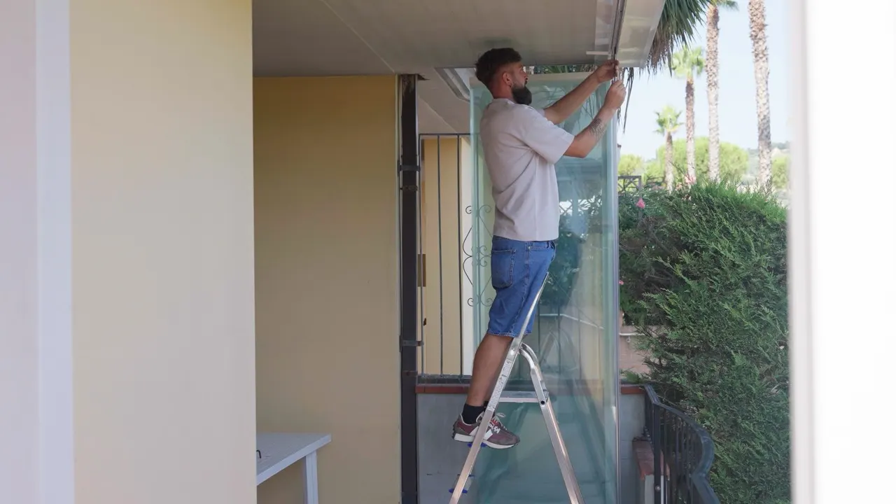 Posatore di Diva Infissi al lavoro su un serramento da un balcone