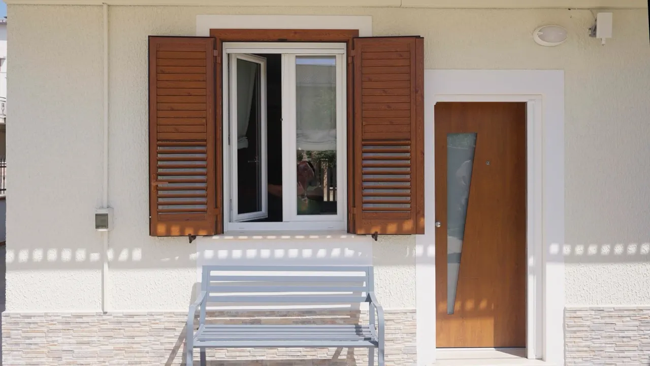 Facciata con persiane in legno, finestra e porta d'ingresso
