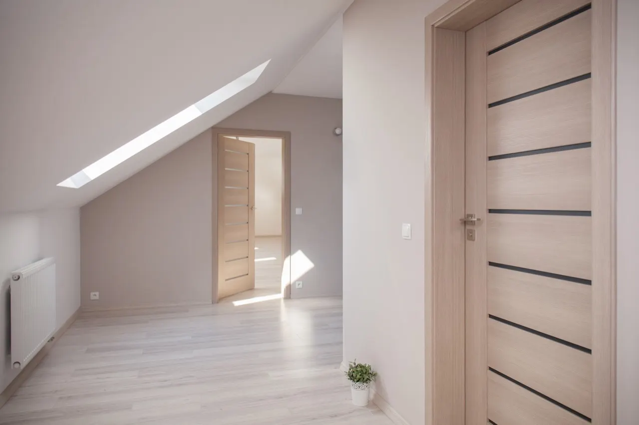Porte interne in laminato effetto legno chiaro in una mansarda