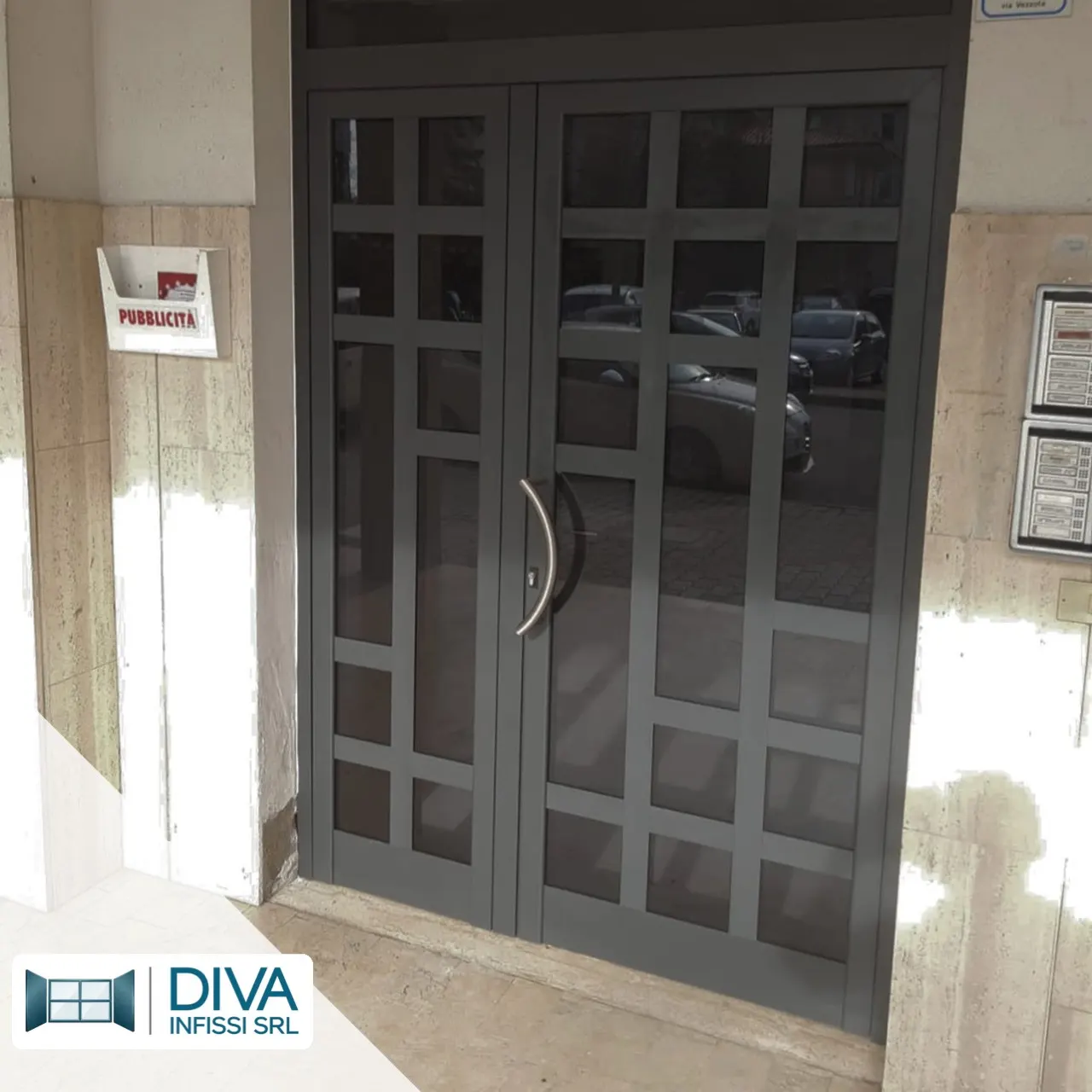 Portone d'ingresso di una palazzina, due ante in alluminio con vetri